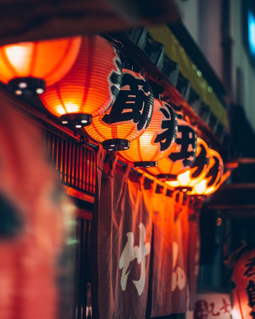 Illuminated Japanese lanterns casting a warm glow outside a restaurant in Tokyo, Japan.