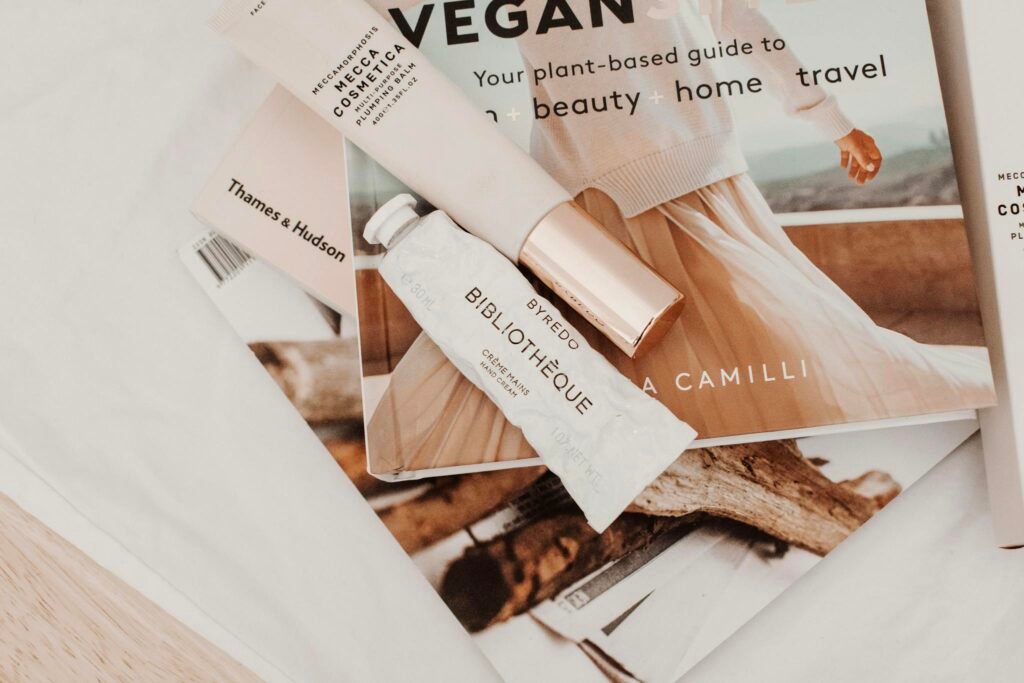 Minimalist flat lay with cosmetics and magazines showcasing modern lifestyle.