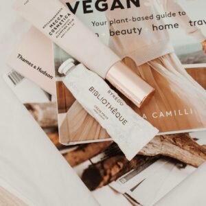 Minimalist flat lay with cosmetics and magazines showcasing modern lifestyle.